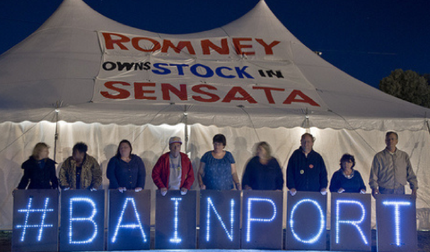 Workers holding letters that say #BAINPORT in front of a large tent