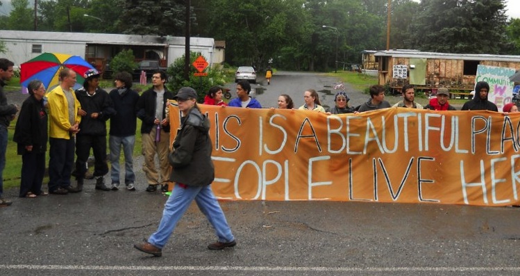 Protesters hold a sign that reads: This is a beautiful place, people live here
