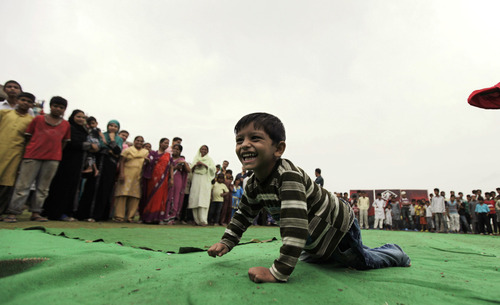 A young boy crawls along Bhopal, India's Special Olympics, organized in response to Dow Chemiclal's deadly gas leak in 1984