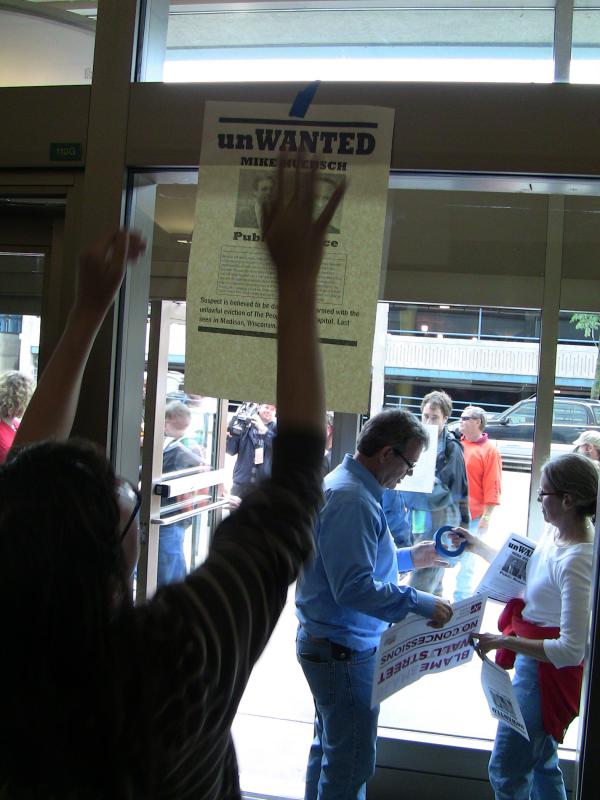 Protestors hang signs inside the Wisconsin Department of Adminsitration