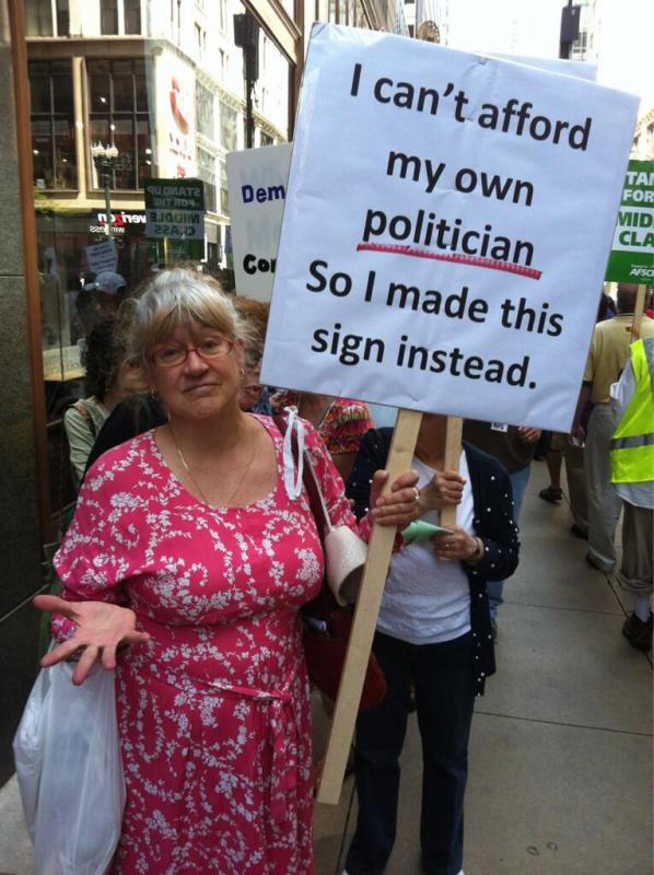 Woman holding sign "I can't afford my own politician so I made this sign instead." (Source: AFSCME Council 30)