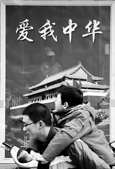 Pedestrians pass by &quot;Love our China&quot; cigarette billboard (from Shenzhen Daily)