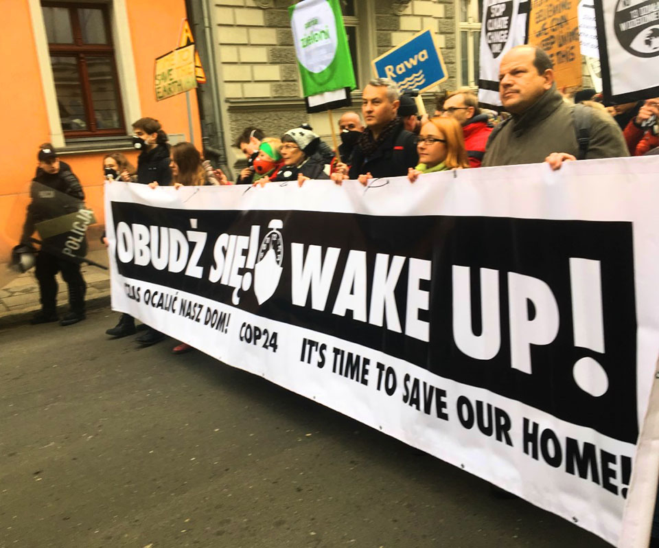 COP 24 "March for Climate" participants carrying a "Wake Up!" banner.