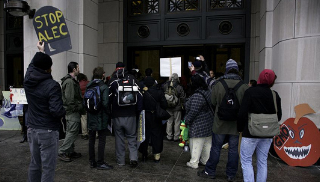 Activists block door to Monsanto headquarters.