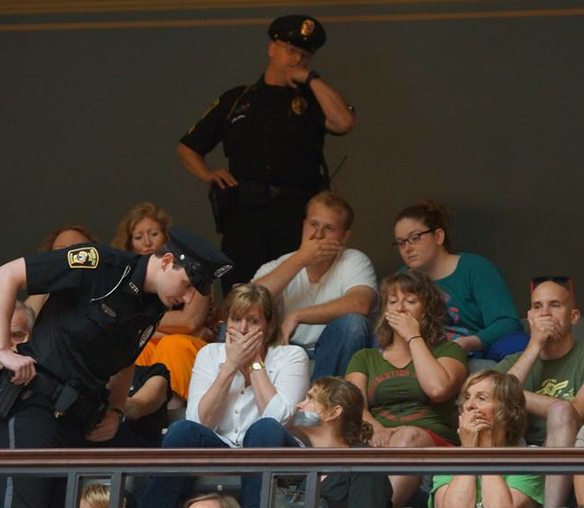 Observers covering their mouths in protest (source: Leslie Peterson)
