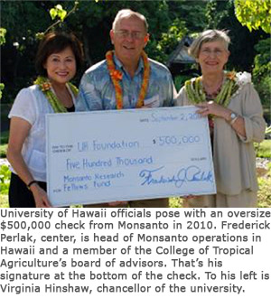 University of Hawaii officials pose with an oversize $500,000 check from Monsanto in 2010