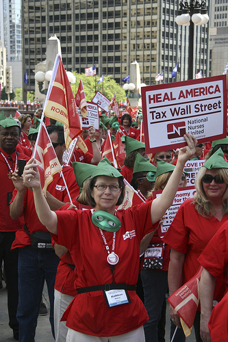Nurse with sign, robin hood hat and mask (Source: National Nurses United)