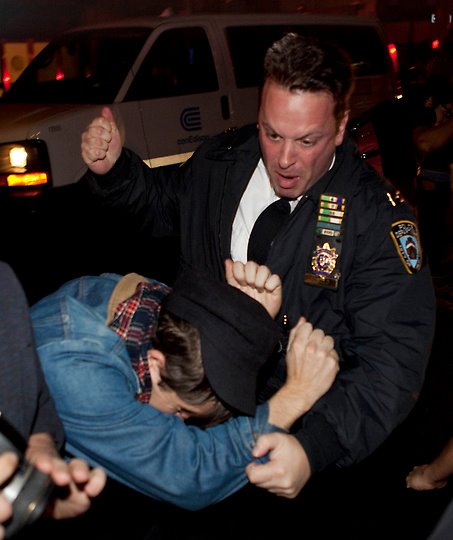 A police officer viciously beats an occupier.