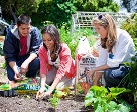 Rosario Dawson gardening at a school next to a bag of Kellogg's Amend