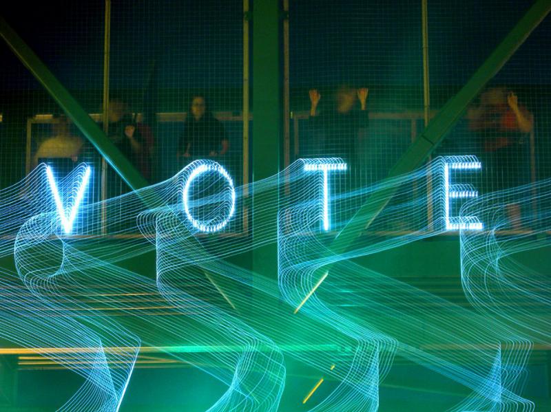 a light up sign that says "vote"