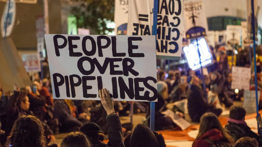 Protesters against the Dakota Access Pipeline and Keystone XL Pipeline hold a sit-in in the street next to the San Francisco Federal Building. (Source: Wikimedia Commons)